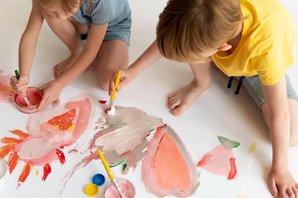 Mãos de criança pintando durante aula de artes