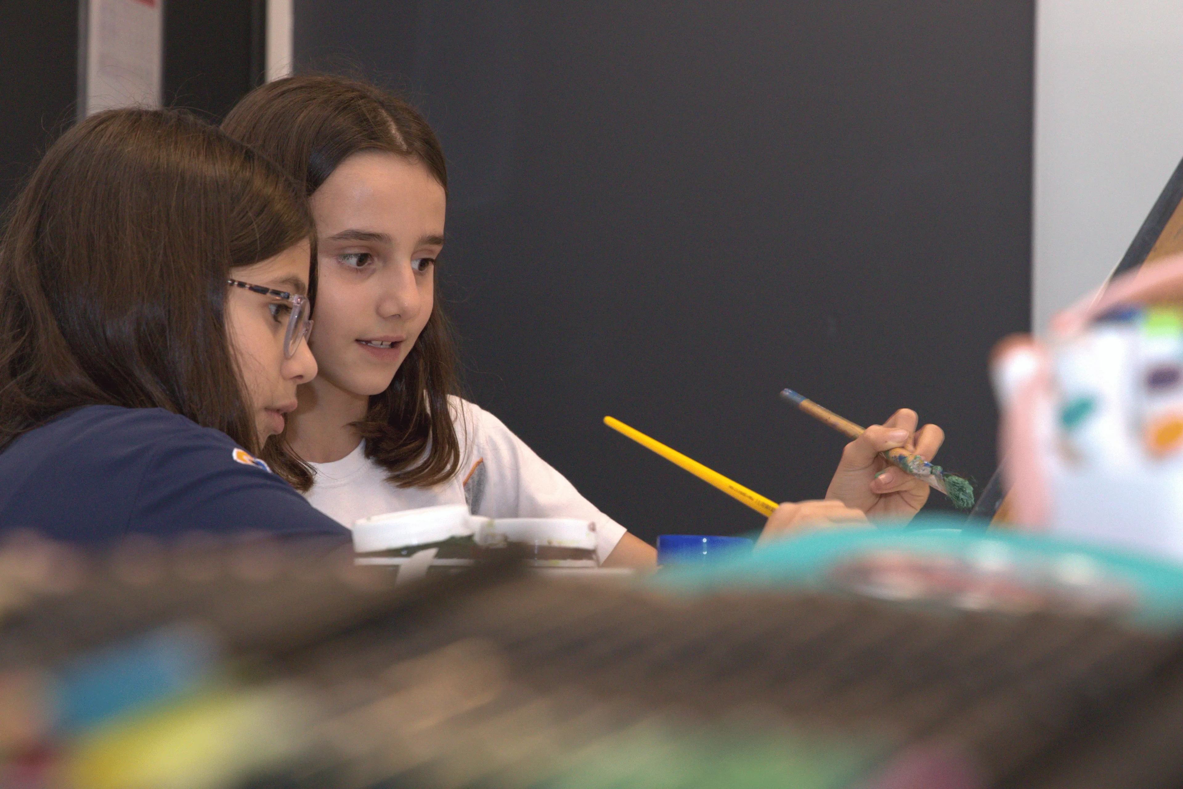 Adolescente aprendendo pintura em sala de aula